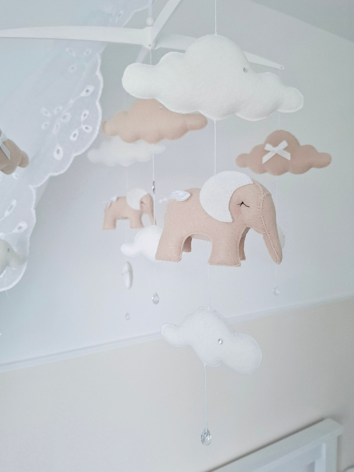 Gentle drift of beige and white elephants with crystal accents, crafted for peaceful movement and luxury nursery décor.