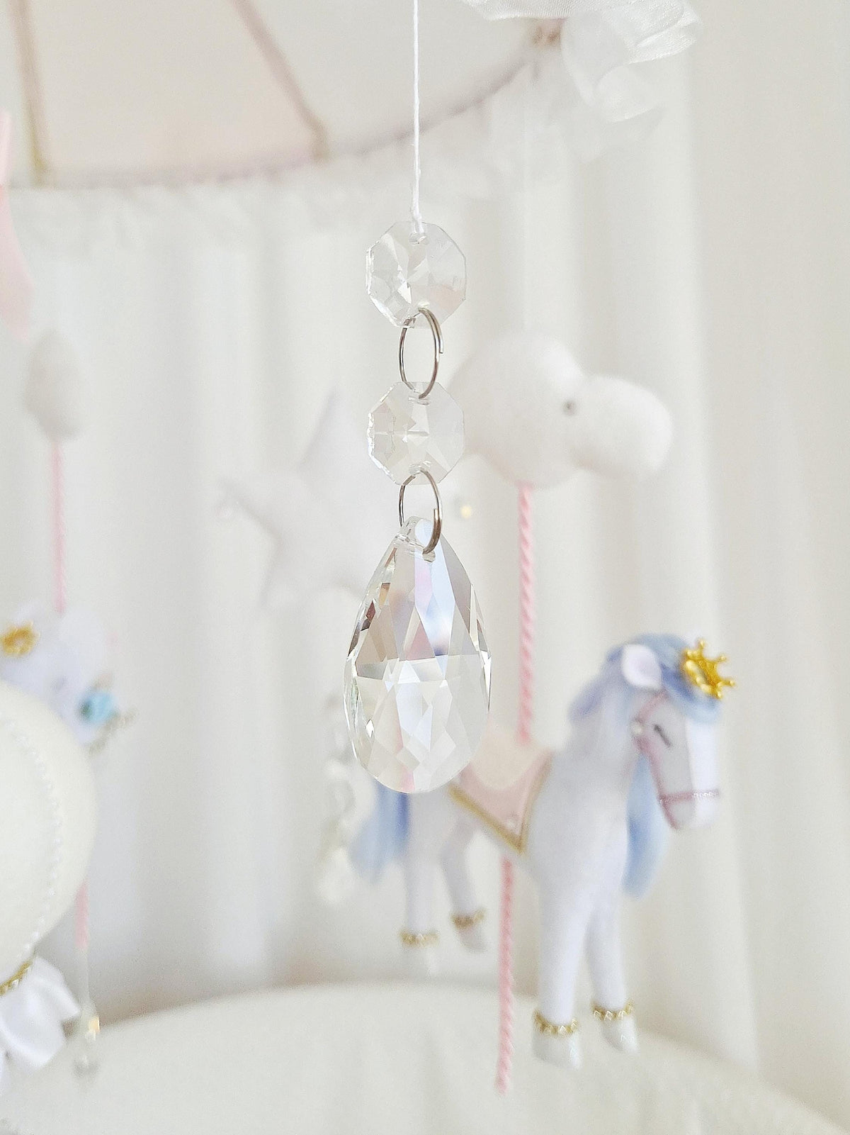 Close-up of the hanging glass crystal prism that catches the light and creates rainbow reflections.