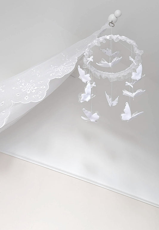 Delicate butterfly baby mobile in all white, handcrafted with soft lace wings and ruffled trim for a pure, peaceful nursery.

