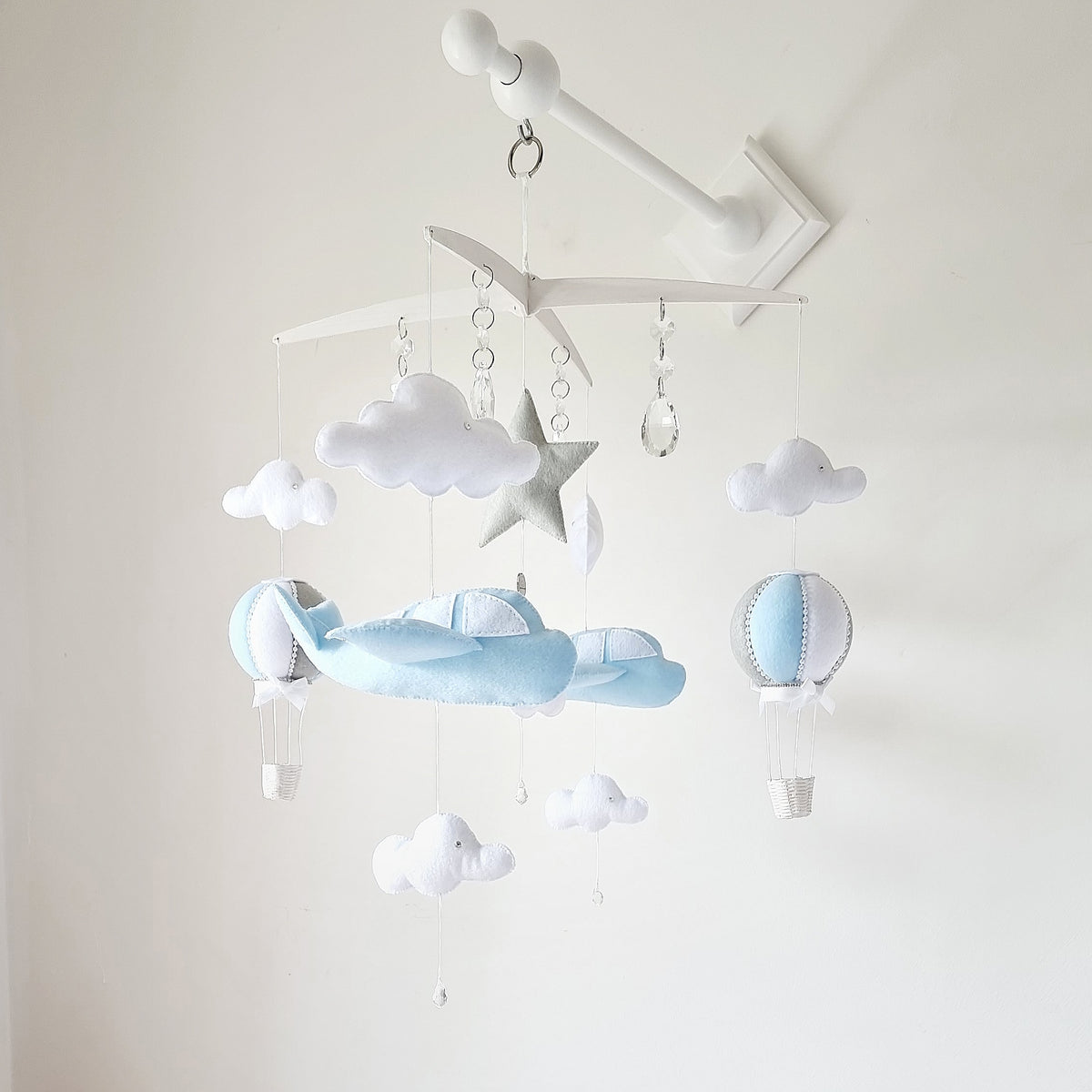 Handmade light blue airplane mobile for baby boys, with felt clouds, star, and a hanging hot air balloon.