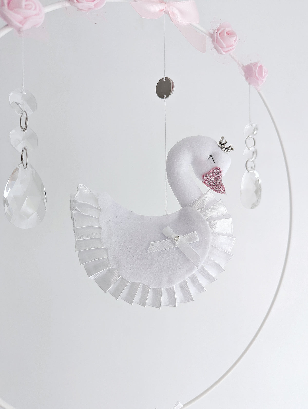 Bespoke swan wall charm with delicate floral garland and soft felt hearts in pink and white.