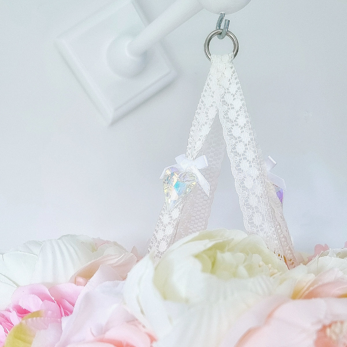 Dreamy mobile featuring a blush butterfly and delicate pink roses beneath a crown of mixed faux florals.