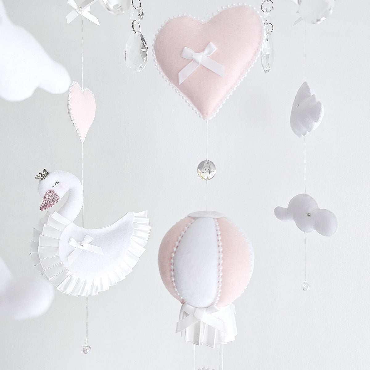 Boutique handmade baby mobile with swans and soft blush accents, a timeless nursery gift.