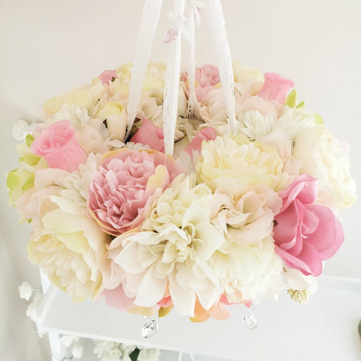 Close-up of the soft swan nestled in silk petals surrounded by delicate floral textures perfect for a romantic baby girl’s space

