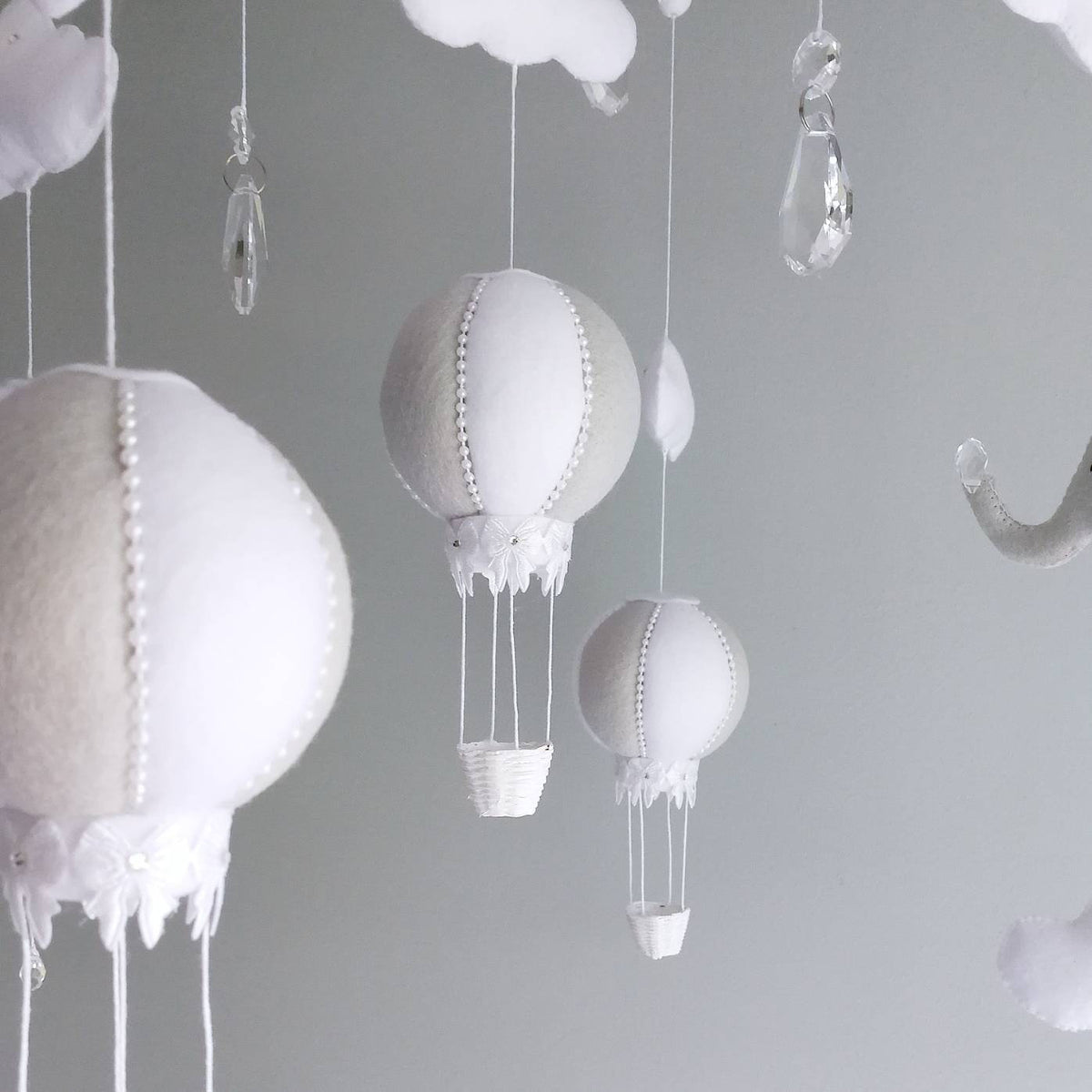 Floating white clouds paired with crystal accents for a touch of sparkle, crafted to create a sense of calm in a baby’s room.

