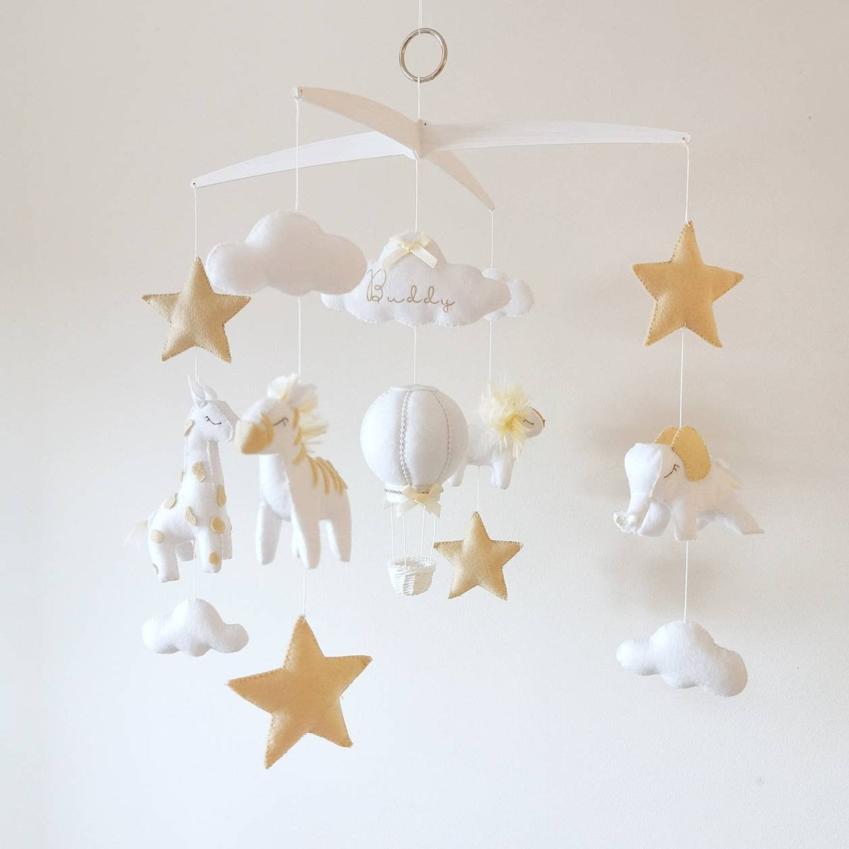Side view of soft safari-themed baby mobile with felt animals in white and beige tones, elegant neutral nursery piece.