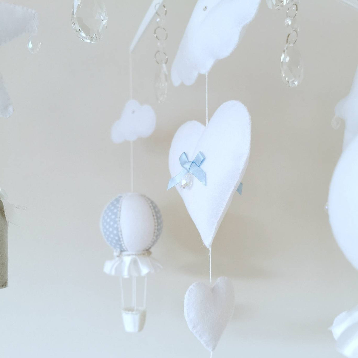 Handmade baby mobile featuring grey and white elephants, hearts, stars, and floating clouds in calming tones.

