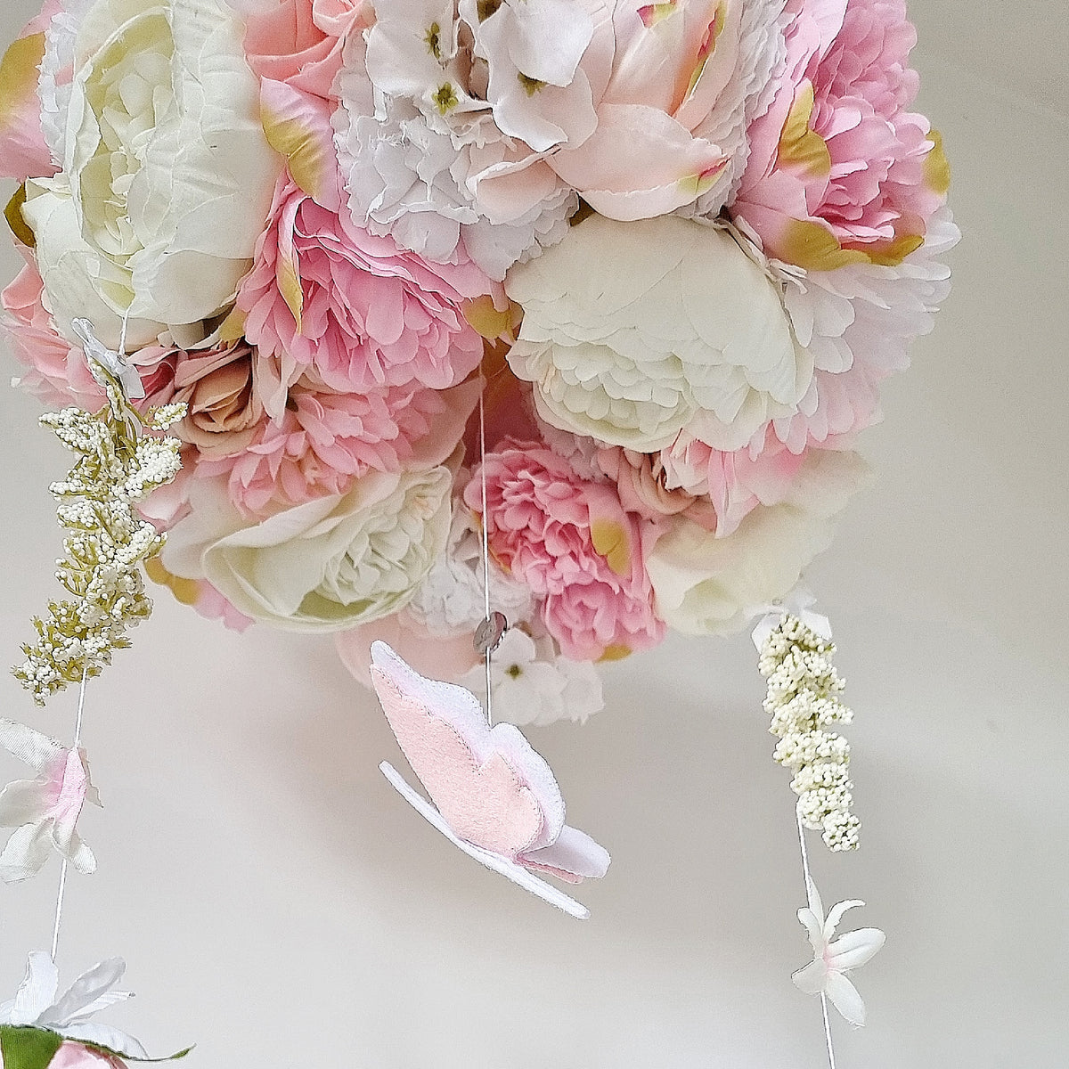 Heirloom-quality floral mobile with layered silk peonies, garden blooms, and a gentle butterfly for a soft pastel nursery.

