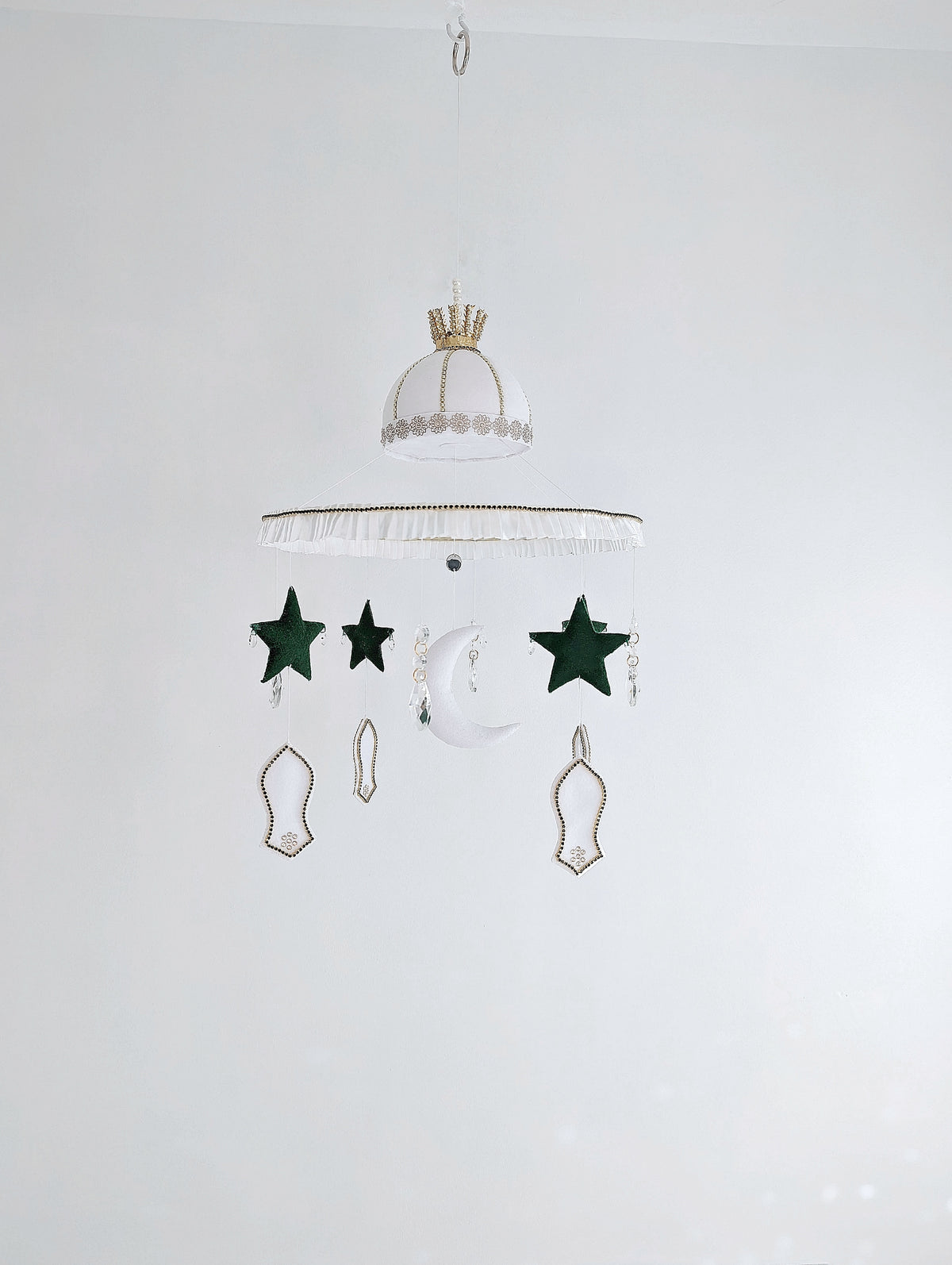 Islamic baby mobile featuring a crescent moon, green stars, and white mosque motifs, handcrafted with love for a peaceful faith-inspired nursery.

