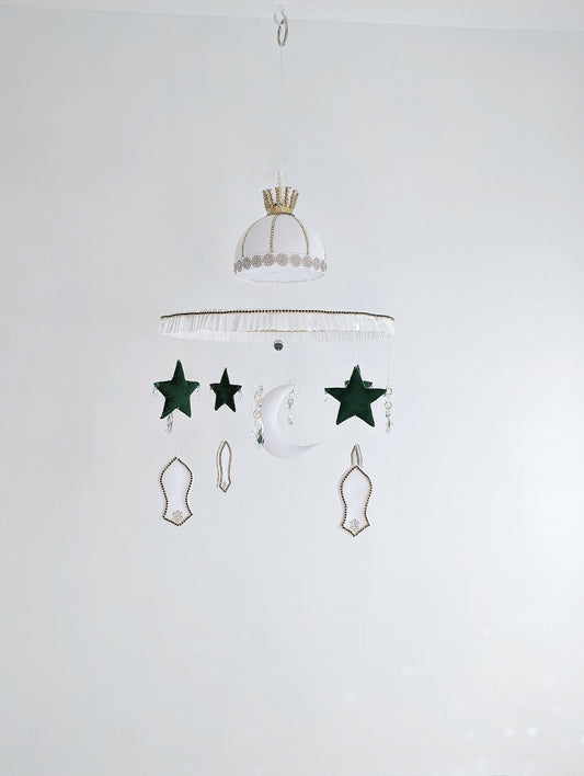 Islamic baby mobile featuring a crescent moon, green stars, and white mosque motifs, handcrafted with love for a peaceful faith-inspired nursery.

