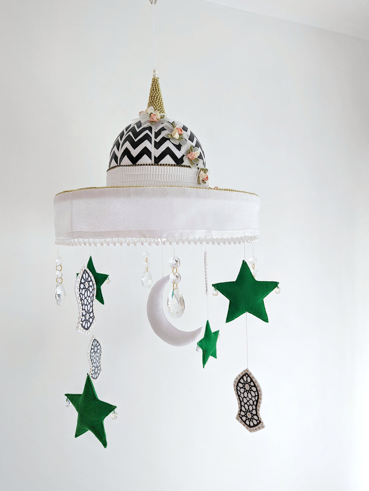  Islamic nursery mobile with green stars, crescent moon, and symbolic Sandal of the Prophet Muhammad (pbuh), set beneath a bold mosque dome.

