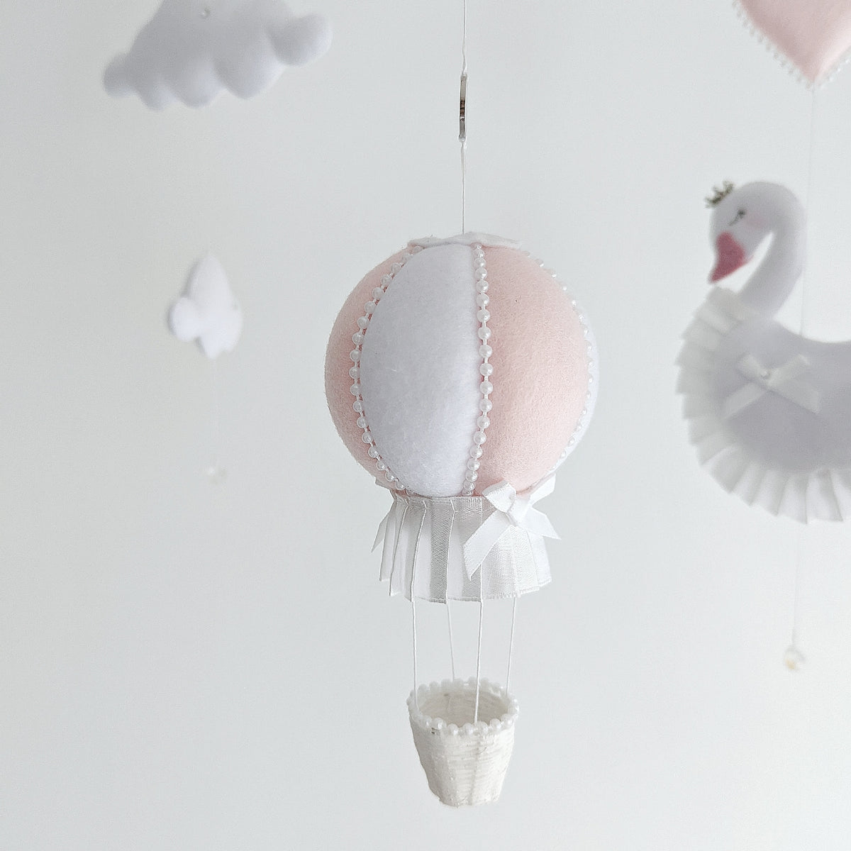 Keepsake baby girl mobile with swans, crystal drops, and a soft white and pink hot air balloon.