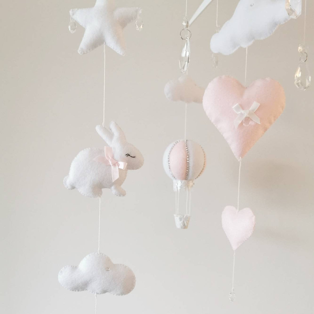 Keepsake baby mobile in blush pink with felt bunny, hot air balloon, and sparkling crystal touches.

