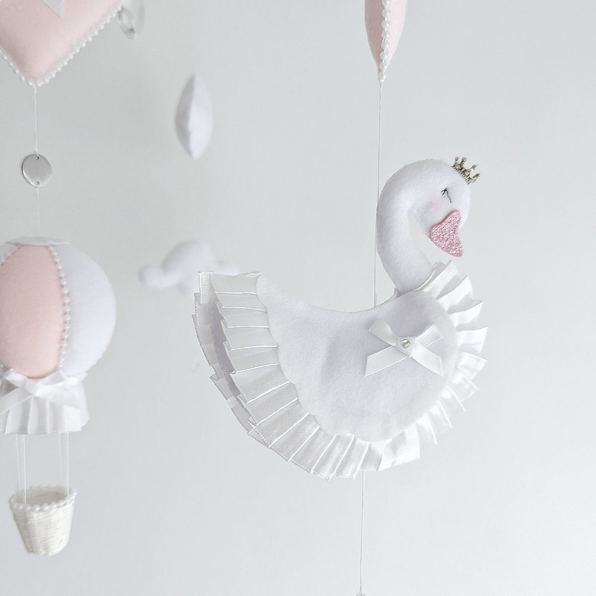 Luxe baby girl mobile featuring princess swans, soft clouds, and a dreamy hot air balloon.