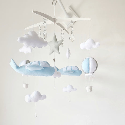 Luxury baby mobile with soft blue airplanes, clouds, and a hot air balloon, handcrafted for a dreamy nursery.