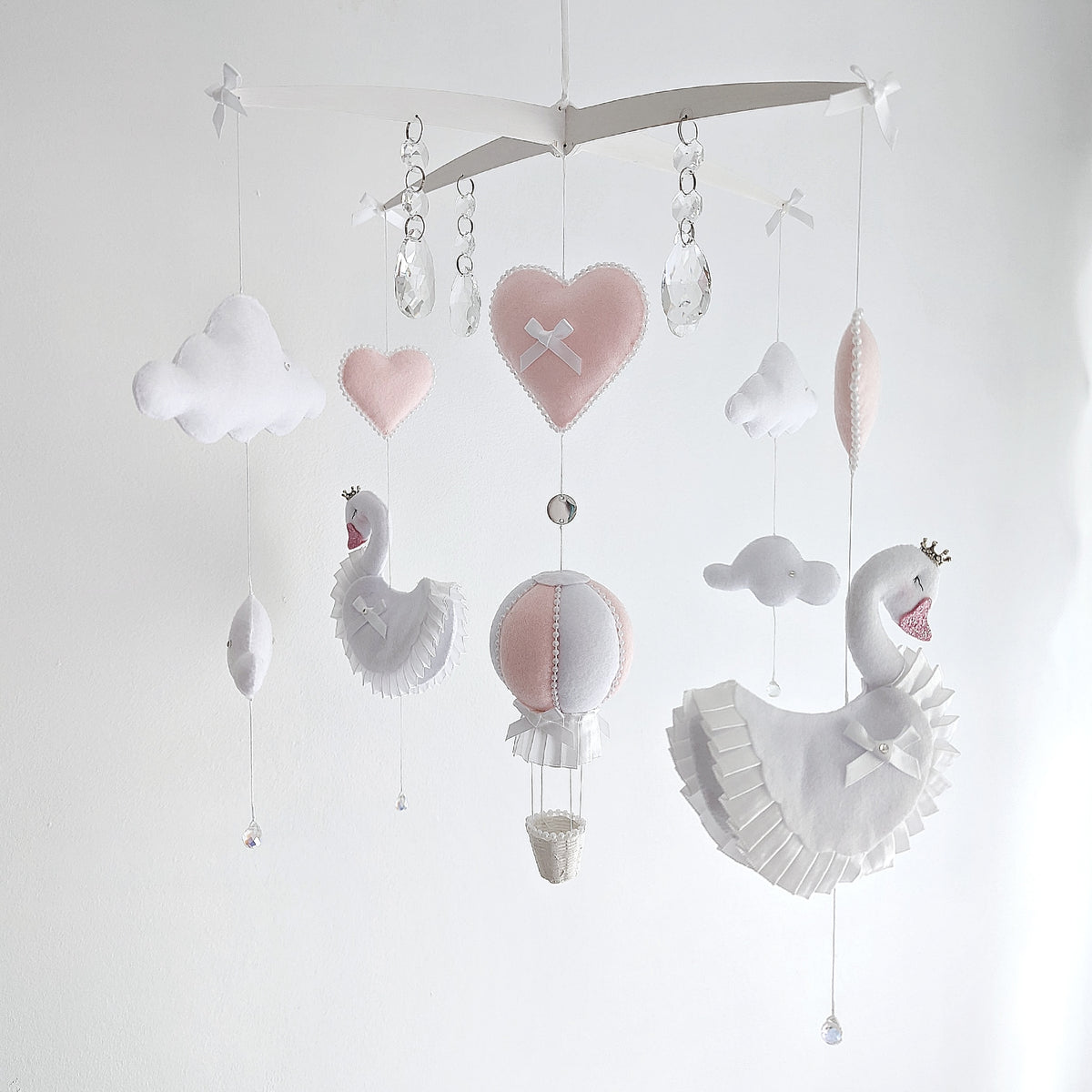 Luxury swan and hot air balloon mobile in blush and white, with soft hearts, clouds, and crystal details.