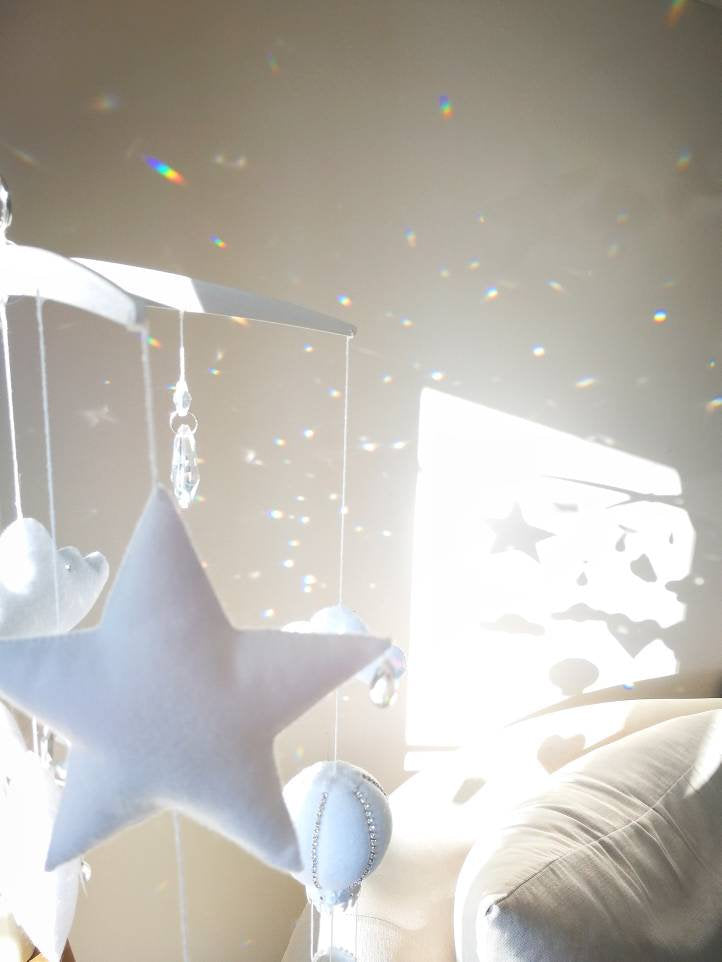 Minimalist nursery mobile with elegant hot air balloons and cloud motifs, perfect for a soft, modern baby room.

