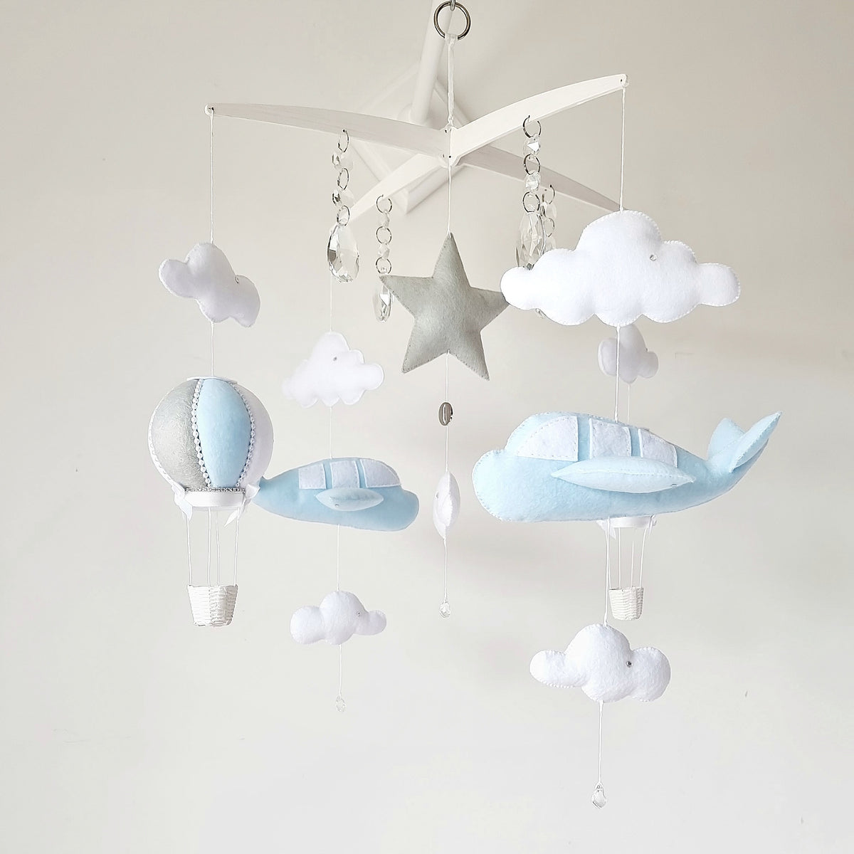 Sky-themed baby mobile featuring airplanes, fluffy clouds, and a silver star on a unique cross-style hanger.