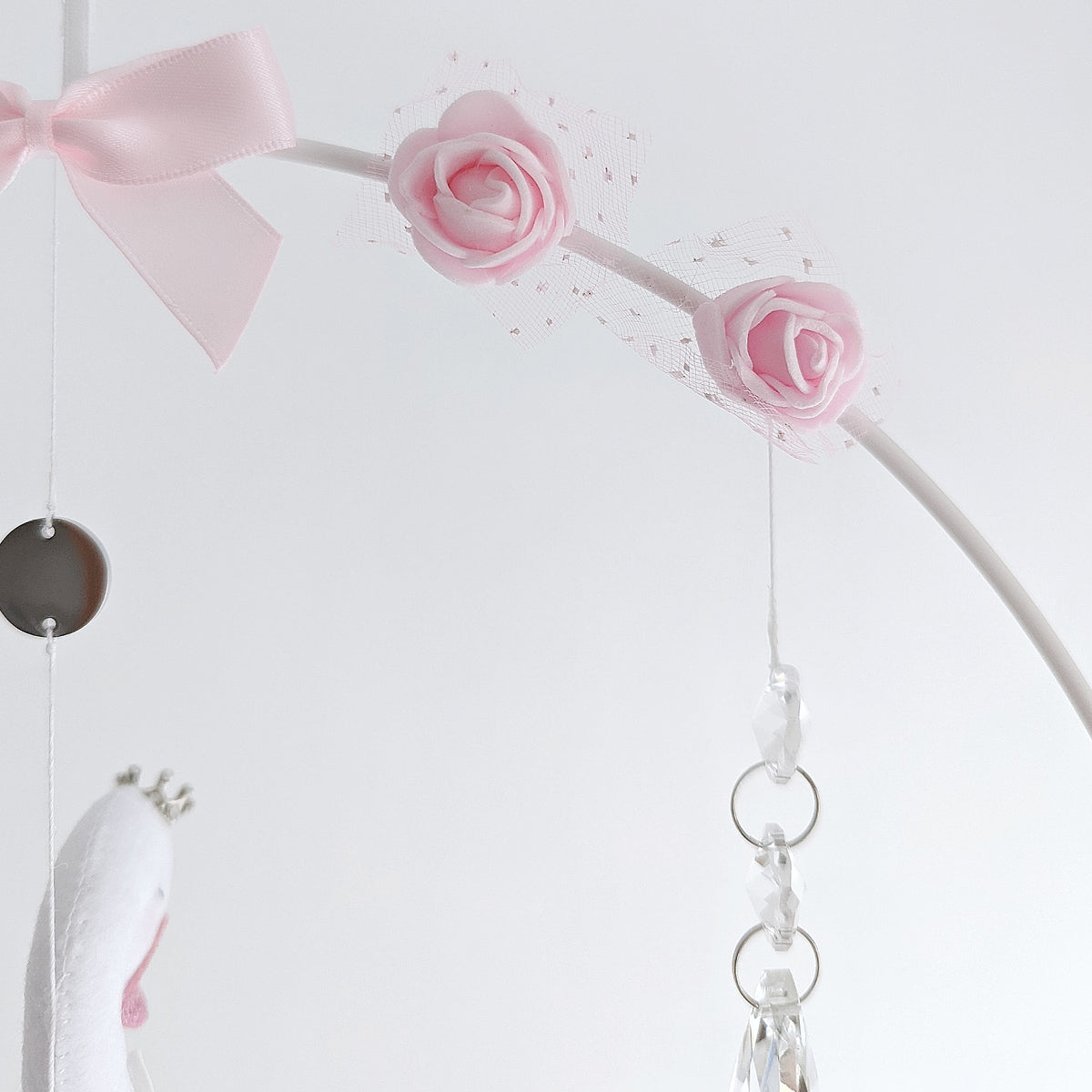 Artful angle of hanging swan charm showing its soft curves, floating hearts, and blush accents, elegant baby girl nursery wall decor.